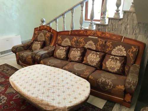 a living room with a couch and a stool at A Royal Luxury Villa In Center With Two Swimming Pools, Sauna and Jacuzzi. in Yerevan