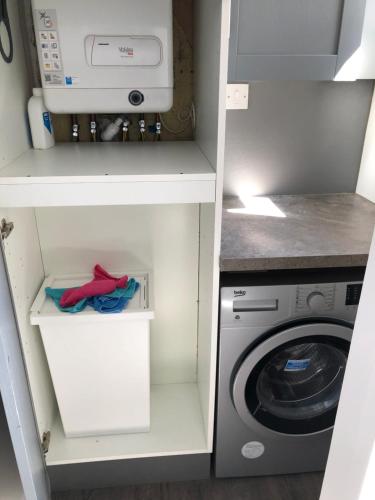 a kitchen with a washer and a washing machine at Replingham Road Apartment in London