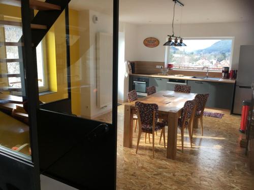 une cuisine et une salle à manger avec une table et des chaises dans l'établissement Les Terrasses du Donon, à Raon-lès-Leau