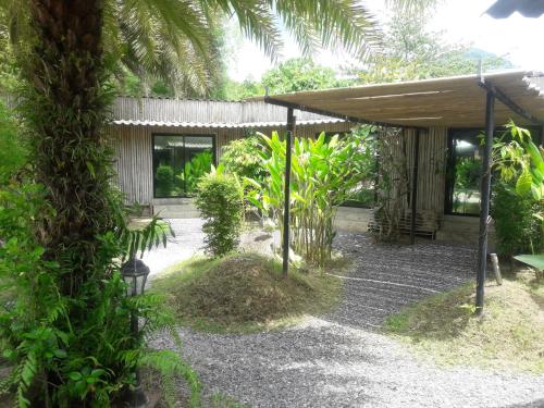 a garden with a pavilion and a palm tree at B Happy Resort - SHA ExtraPlus in Kamala Beach