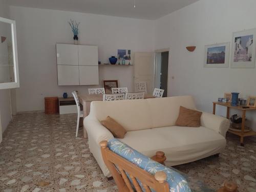 een woonkamer met een witte bank en een keuken bij Villa Frida in Campomarino