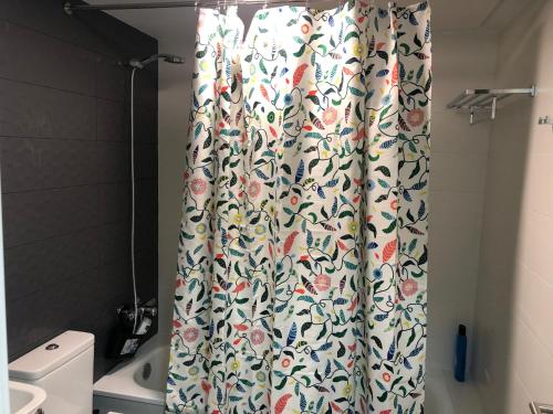 cortina de ducha con motivos florales en el baño en Suite Home Los Alamos sol, playa y golf , parking&Wifi, en Torremolinos
