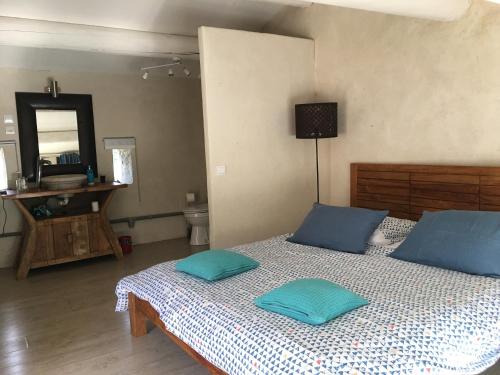 um quarto com uma cama com almofadas azuis em Mas à Cheval-Blanc en Provence em Cheval-Blanc