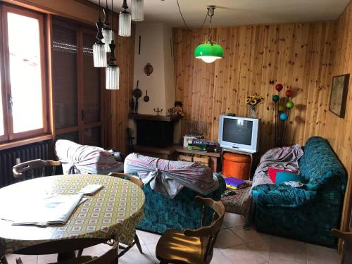 a living room with a couch and a table and a tv at Borno, Appartamento nel centro del paese in Borno