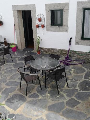 a patio with a table and chairs on a stone floor at Pensión Mar in Portomarin