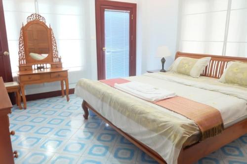 a bedroom with a large bed and a table at Majestic Villas Guesthouse Phuket. in Rawai Beach