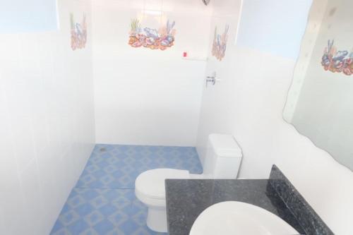 a bathroom with a white toilet and a blue tile floor at Majestic Villas Guesthouse Phuket. in Rawai Beach