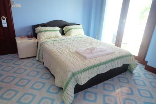 a bedroom with a bed with a white comforter at Majestic Villas Guesthouse Phuket. in Rawai Beach