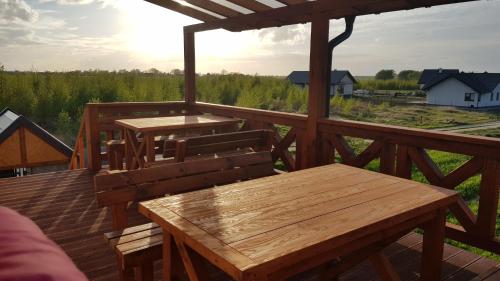 - une terrasse en bois avec une table et des bancs dans l'établissement Szczere Pole Nad Morzem, à Strzezenice