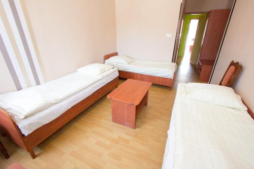 a room with two beds and a table in it at Wisełka PERŁA Bałtyku in Wisełka