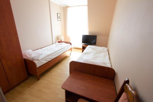 a small room with two beds and a chair at Wisełka PERŁA Bałtyku in Wisełka
