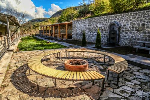 a bench and a fire pit in a yard at Lara Hotel in Goris