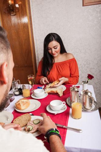 een vrouw zit aan een tafel eten bij Hotel Pension Wiesenau in Bad Salzhausen