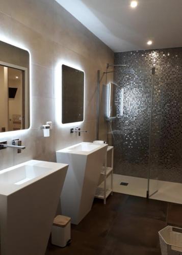 une salle de bain avec deux lavabos et une douche dans l'établissement L'oliveraie du Fango, à Manso