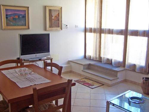 a living room with a table and a television at Casa Liliana in Oristano