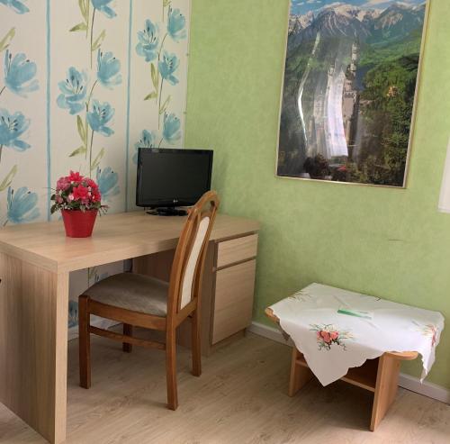a room with a table and a chair and a desk at Hotel Pension Wiesenau in Bad Salzhausen