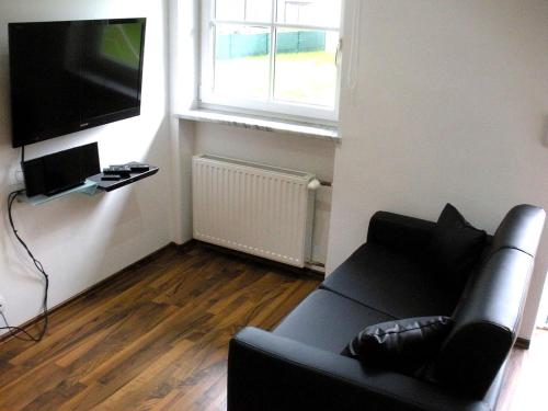 ein Wohnzimmer mit einem Sofa und einem Flachbild-TV in der Unterkunft Easyapartments Countryside in Salzburg