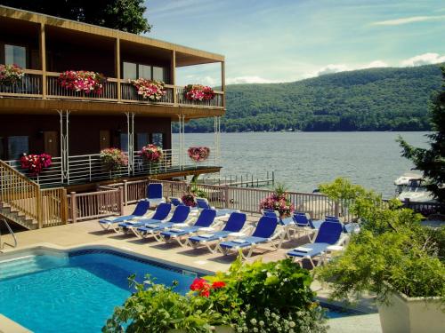 a resort with a swimming pool and lounge chairs at Lake Crest Inn in Lake George