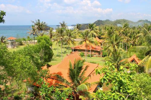 an aerial view of a resort with palm trees and the ocean at Desa Limasan Resort in Kalak