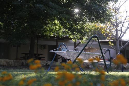 a playground in a yard with flowers in the grass at Kibbutz Beit Alfa Guest House in Bet Alfa