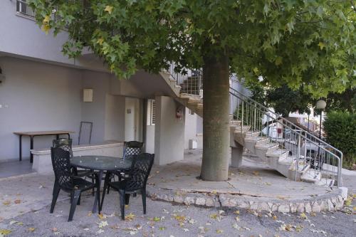 a table and chairs under a tree in front of a building at Kibbutz Beit Alfa Guest House in Bet Alfa