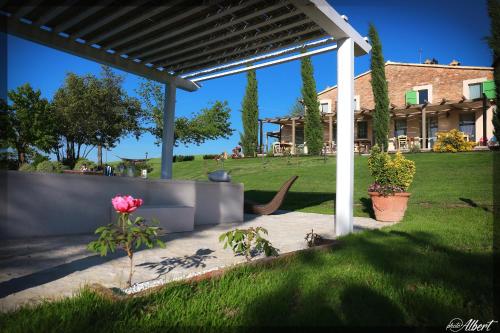 a pergola with a pink rose in a yard at Le Maraclà Country House in Iesi