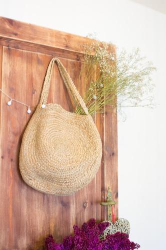 a straw purse hanging on a wooden wall at Wisełka PERŁA Bałtyku in Wisełka