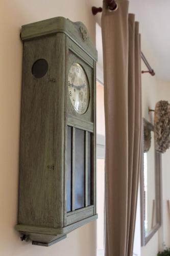 a wooden clock on a wall next to a window at Wisełka PERŁA Bałtyku in Wisełka