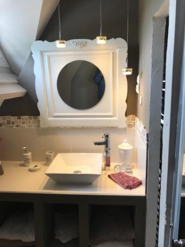 W łazience znajduje się umywalka i lustro. w obiekcie le jardin adele w mieście Drucat