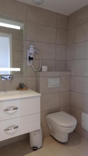 a bathroom with a toilet and a sink and a mirror at Résidence les Hameaux de Bocca del Oro in Porto-Vecchio