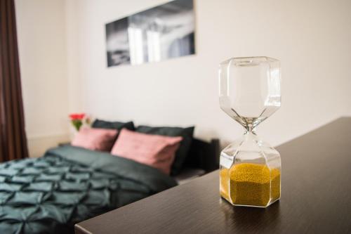 a hourglass sitting on top of a table next to a bed at Apartman JnJ Velkomoravska in Olomouc