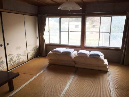 a bed in a room with a large window at Guesthouse Fuki Juku in Fuki