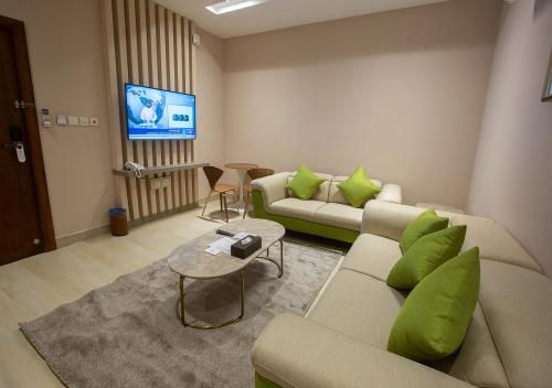 Banan Hotel Suites في تبوك: غرفة معيشة مع كنبتين وتلفزيون