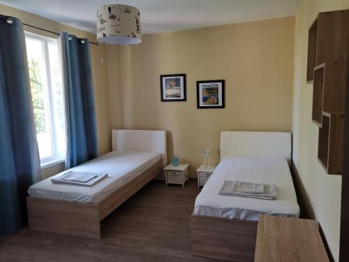 1 dormitorio con 2 camas y ventana en BURGAS SEA APARTMENT, en Burgas
