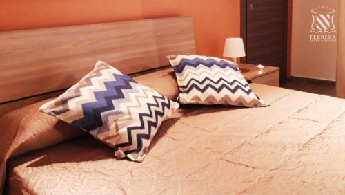 2 almohadas sentadas encima de una cama en Eclisse House - close to the beach, en Villaggio San Leonardo