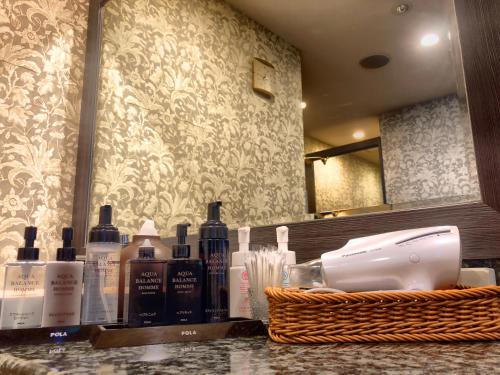 a counter with bottles of hair products and a basket at Hotel Coco Grand Kitasenju in Tokyo