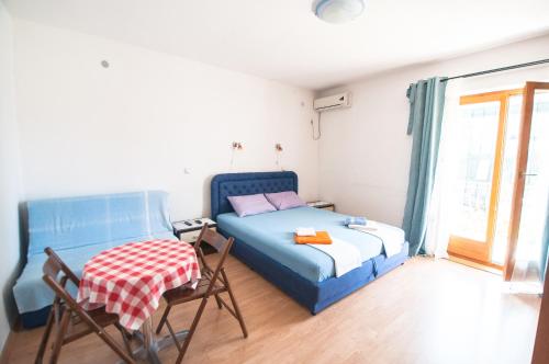 Schlafzimmer mit einem Bett, einem Tisch und Stühlen in der Unterkunft Apartments Milena in Tivat