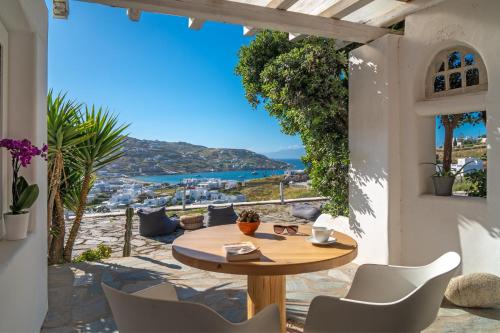 una mesa y sillas en un patio con vistas al océano en Ornos Blue, en Ornos