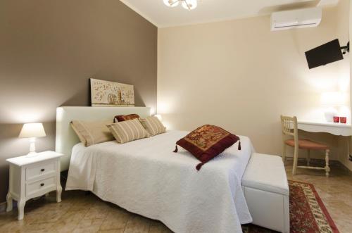 a bedroom with a white bed and a desk at Saint Philippe Maison in Aci Catena