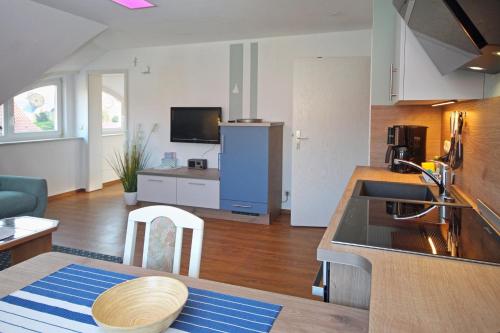 eine Küche und ein Wohnzimmer mit einem Tisch und einem Sofa in der Unterkunft Ferienwohnungen Fründt in Prerow