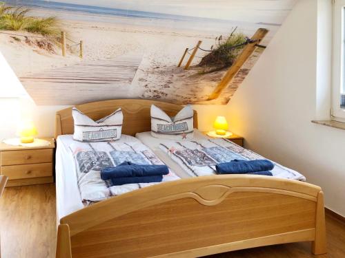 a bedroom with a bed with a painting of the beach at Ferienwohnungen Fründt in Prerow