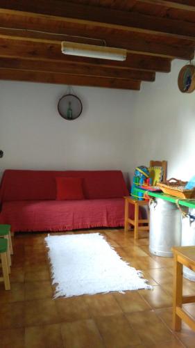 a red couch in a living room with a rug at A Minguxaina in Ribadeo