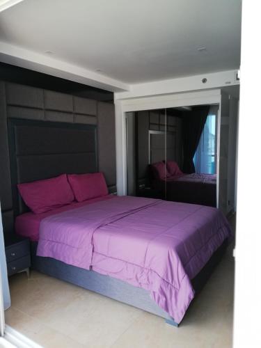 a bedroom with a purple bed with a mirror at Centara Avenue apartment 711 in Pattaya
