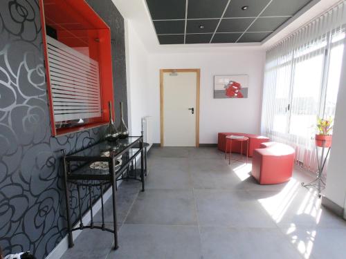 a waiting room with red chairs and a door at Hotel Mercedes in Camargo
