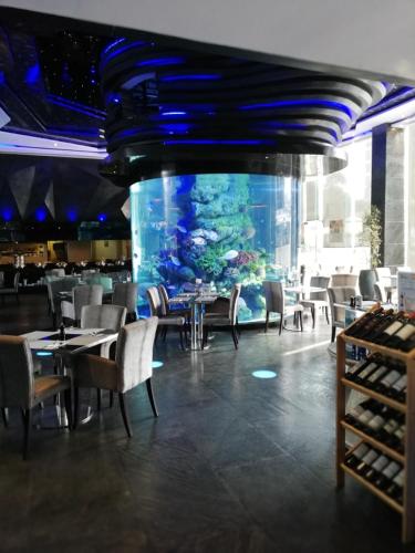 a dining room with an aquarium and tables and chairs at Centara Avenue apartment 711 in Pattaya