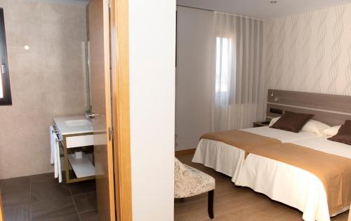 a bedroom with a bed and a table and a desk at Hotel Mercedes in Camargo