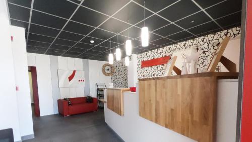 a lobby with black and white ceilings and a red couch at Hotel Mercedes in Camargo