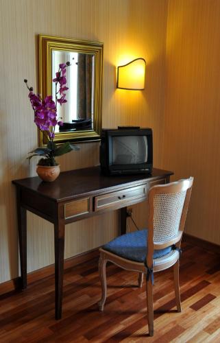 a room with a desk with a tv and a chair at Grande Albergo Quattro Stagioni in Rieti