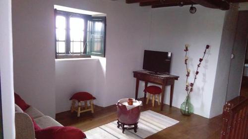 uma sala de estar com um sofá e um piano em A Minguxaina em Ribadeo
