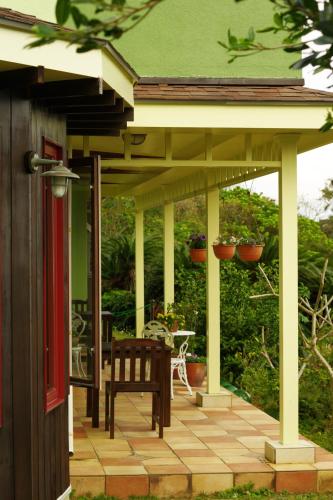 a covered porch with a bench on a house at Villa Yurimun in Tatsugo